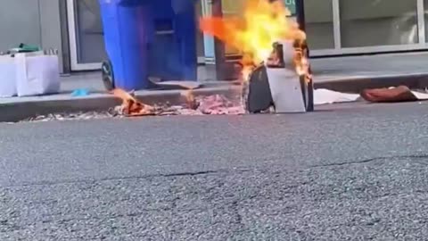 Homeless man catching things on fire in the middle of the road.