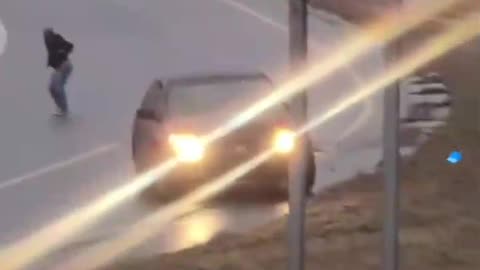 A Kansas City woman exits her vehicle as it slides down the hill on black ice.