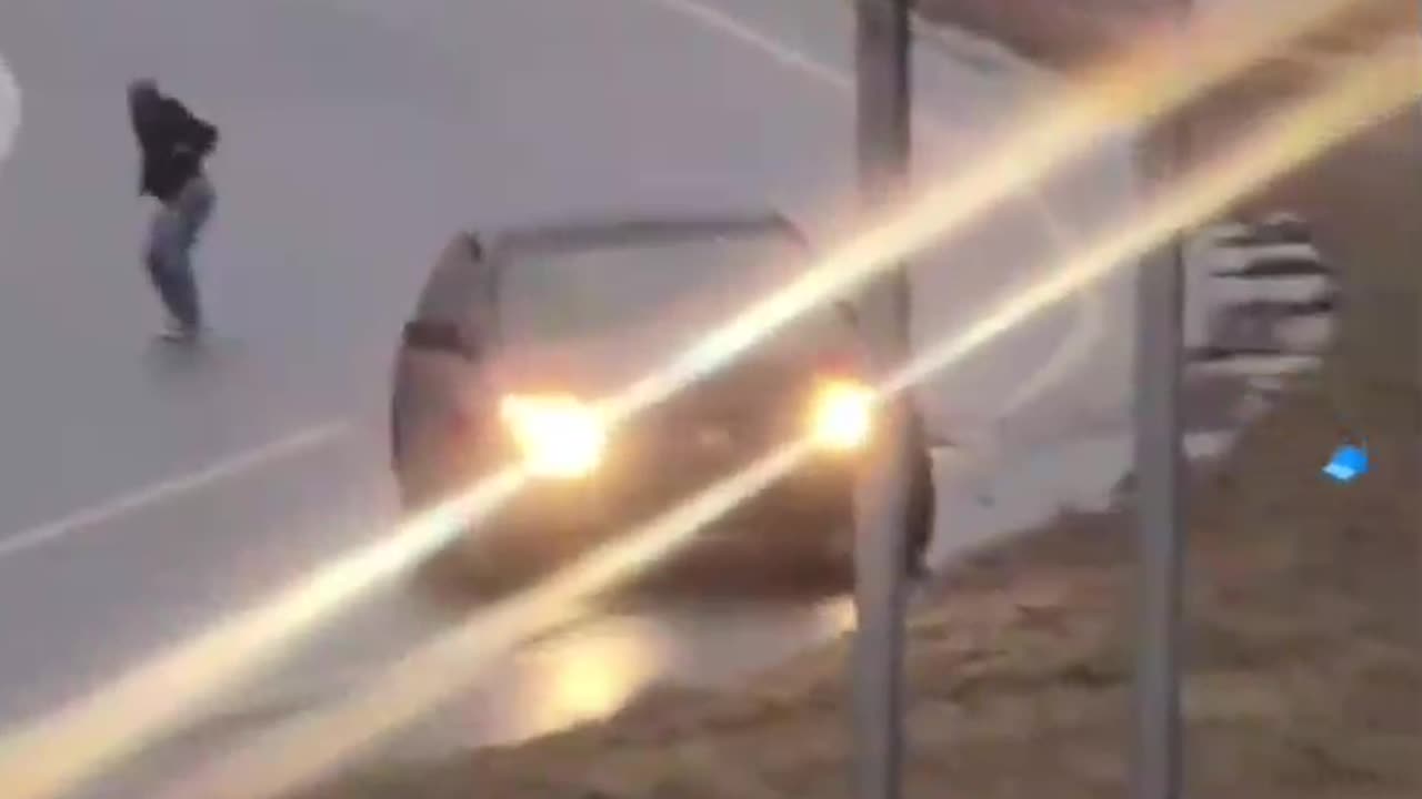 A Kansas City woman exits her vehicle as it slides down the hill on black ice.