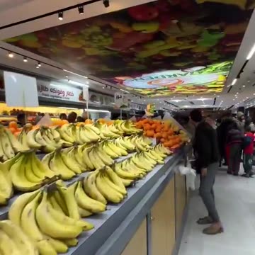 Palestinian man shows off abundance of fresh food in a Gaza supermarket