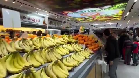 Palestinian man shows off abundance of fresh food in a Gaza supermarket