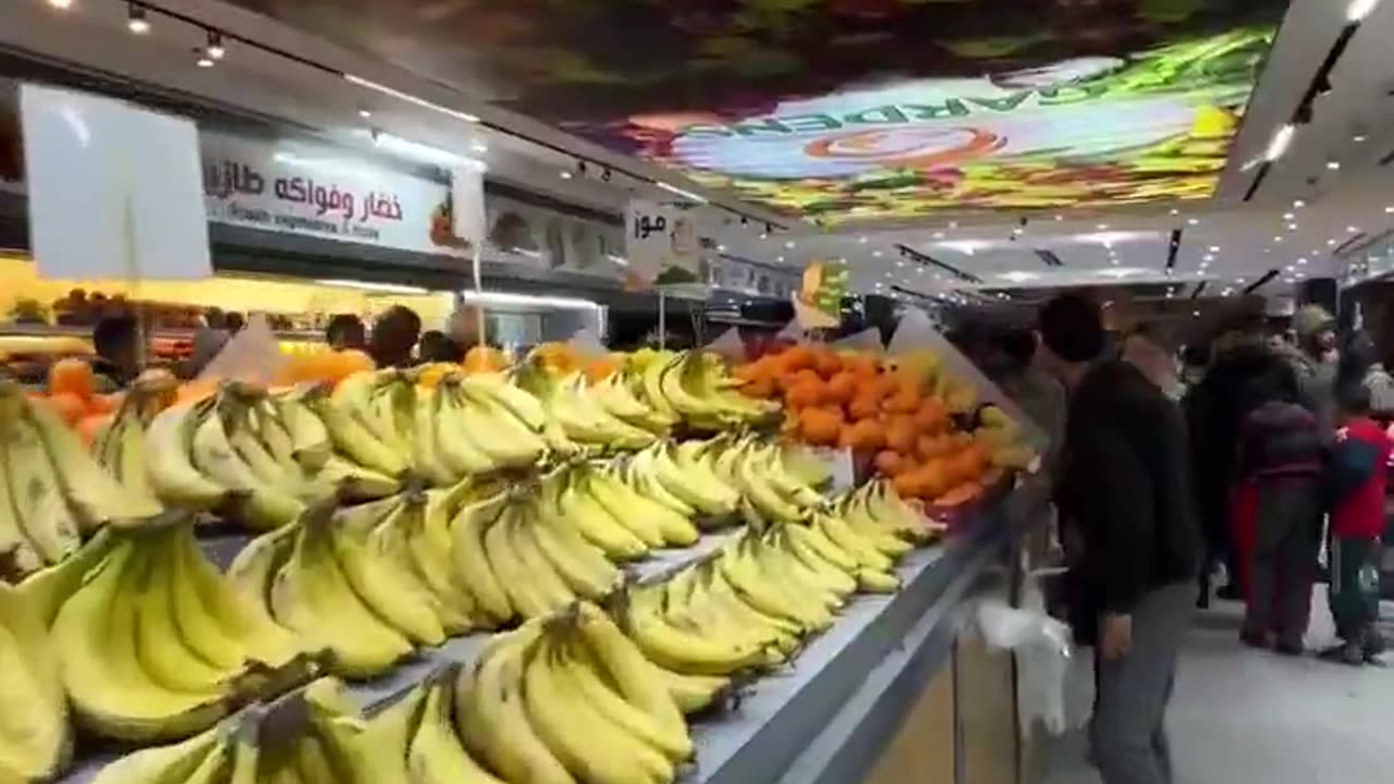 Palestinian man shows off abundance of fresh food in a Gaza supermarket