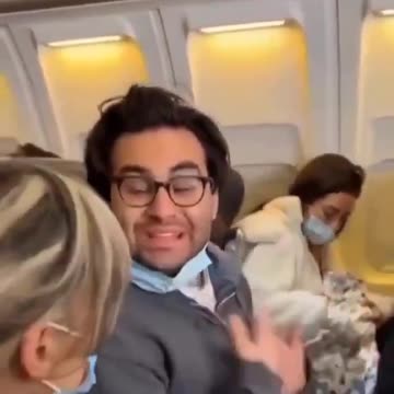 Shes breastfeeding a cat on a plane.