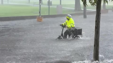 Bicycle Courier Rides Through Flooded to Street to Make Delivery