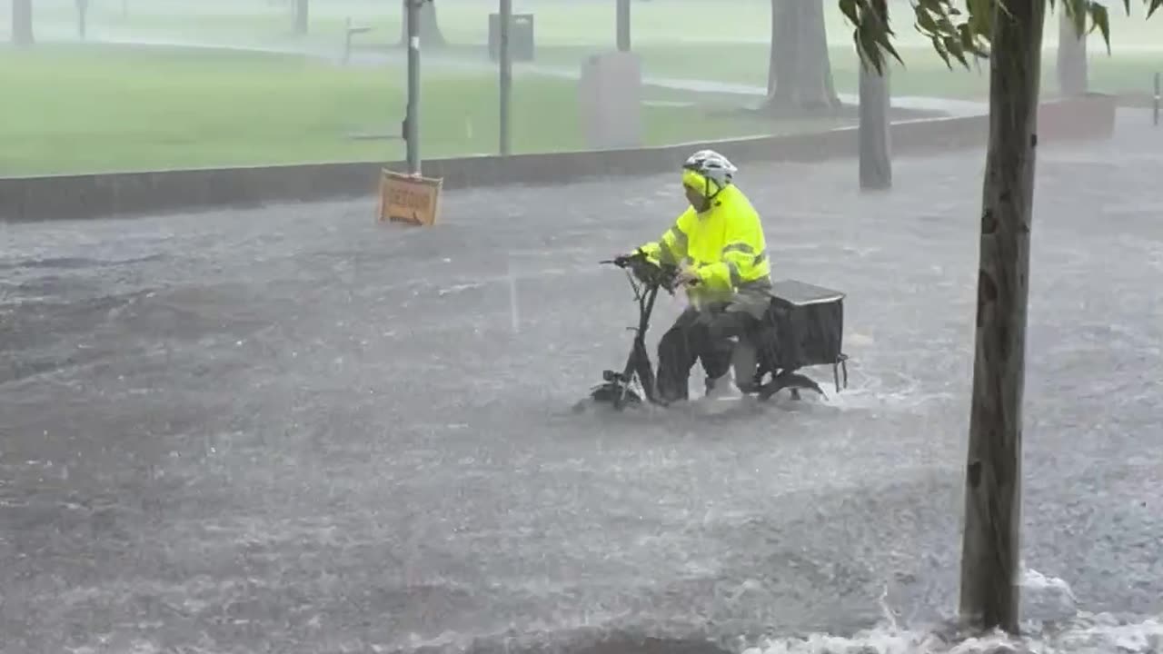 Bicycle Courier Rides Through Flooded to Street to Make Delivery