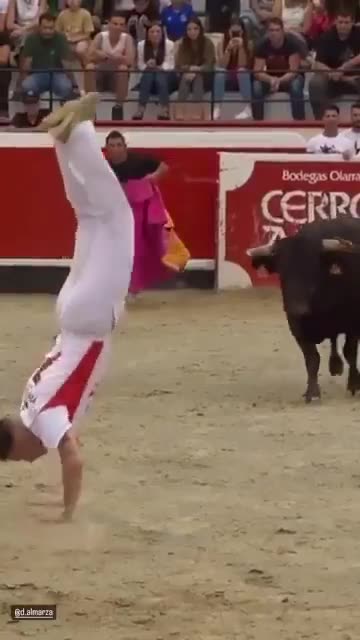 Man does a backflip over a charging bull