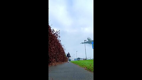 ✈️ A plane flying high in the sky while boy stand on ground