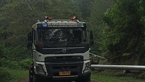 Convoy of heavy load container trucks on a sharp incline