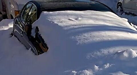 Car buried in deep hardened snow - city parking