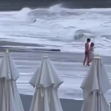 悲劇。海が荒れている日に浜辺を訪れたカップル