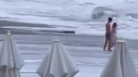 悲劇。海が荒れている日に浜辺を訪れたカップル