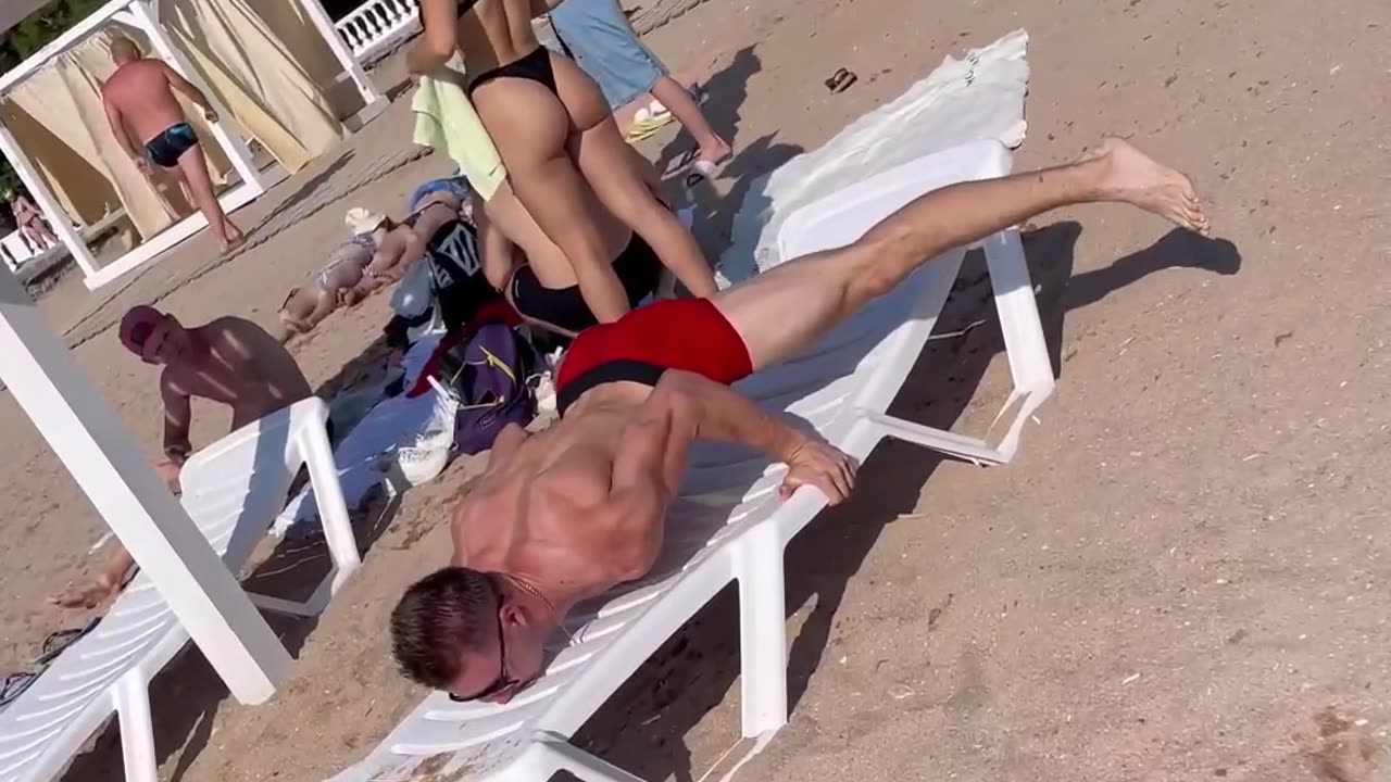 Man Demonstrates Muscled Balance On Beach Chair