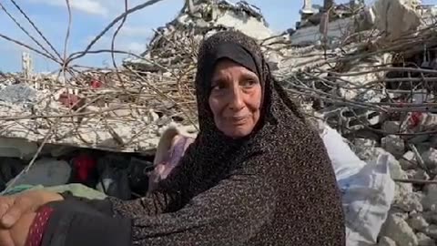 Mother sits on the ruins of her house - Asks for a pillow or a matteress