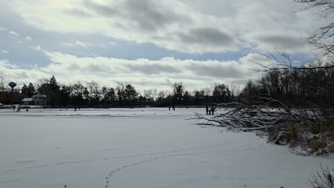 Frozen Neighborhood Pond with People Skating
