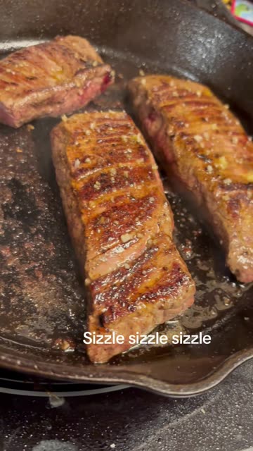 Flank Steaks Sizzling on Cast Iron