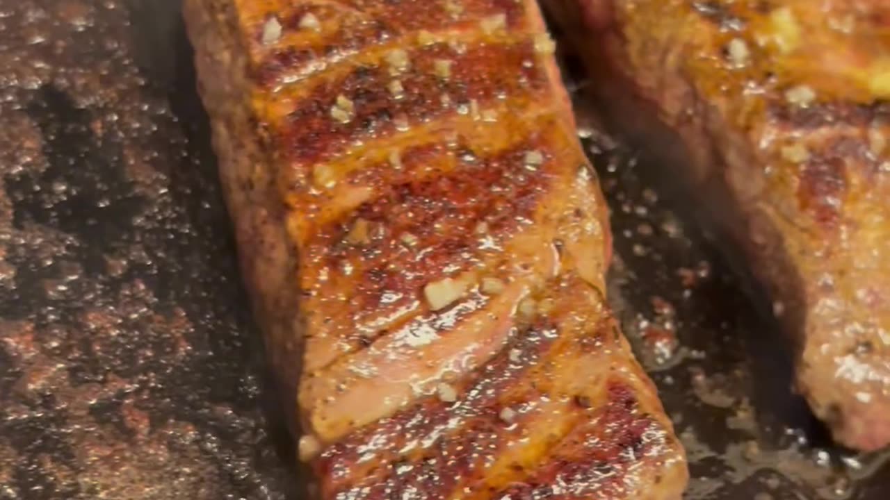 Flank Steaks Sizzling on Cast Iron