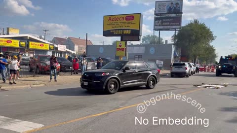 Chaotic scene as some in the crowd throw projectiles towards law enforcement vehicles