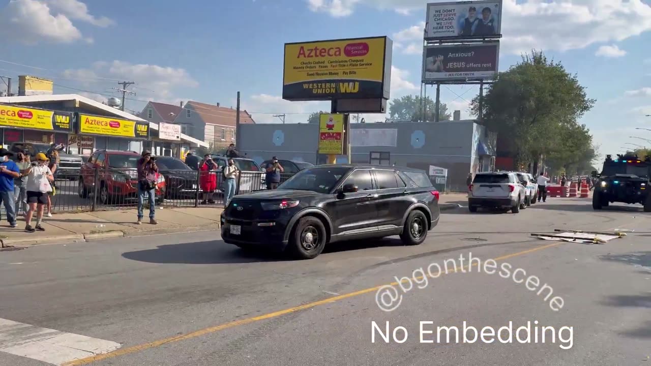 Chaotic scene as some in the crowd throw projectiles towards law enforcement vehicles