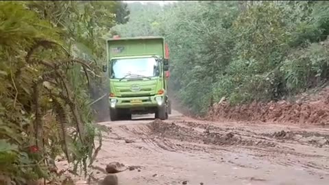 heavy load truck going uphill on muddy road