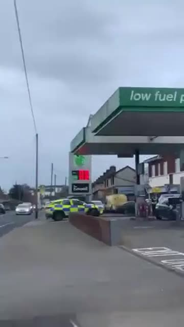 Dublin, Ireland. Man jumps from garage forecourt roof onto police car.