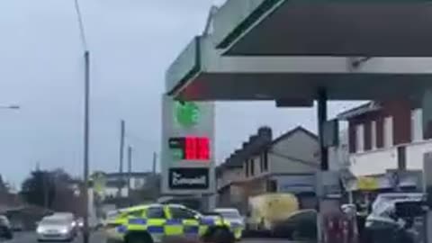 Dublin, Ireland. Man jumps from garage forecourt roof onto police car.