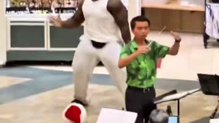 Man disrupts & mocks an all Asian orchestra performing Christmas carols in a mall