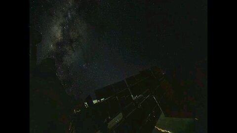 A timelapse of solar arrays reflecting aurora and city lights as they align themselves.