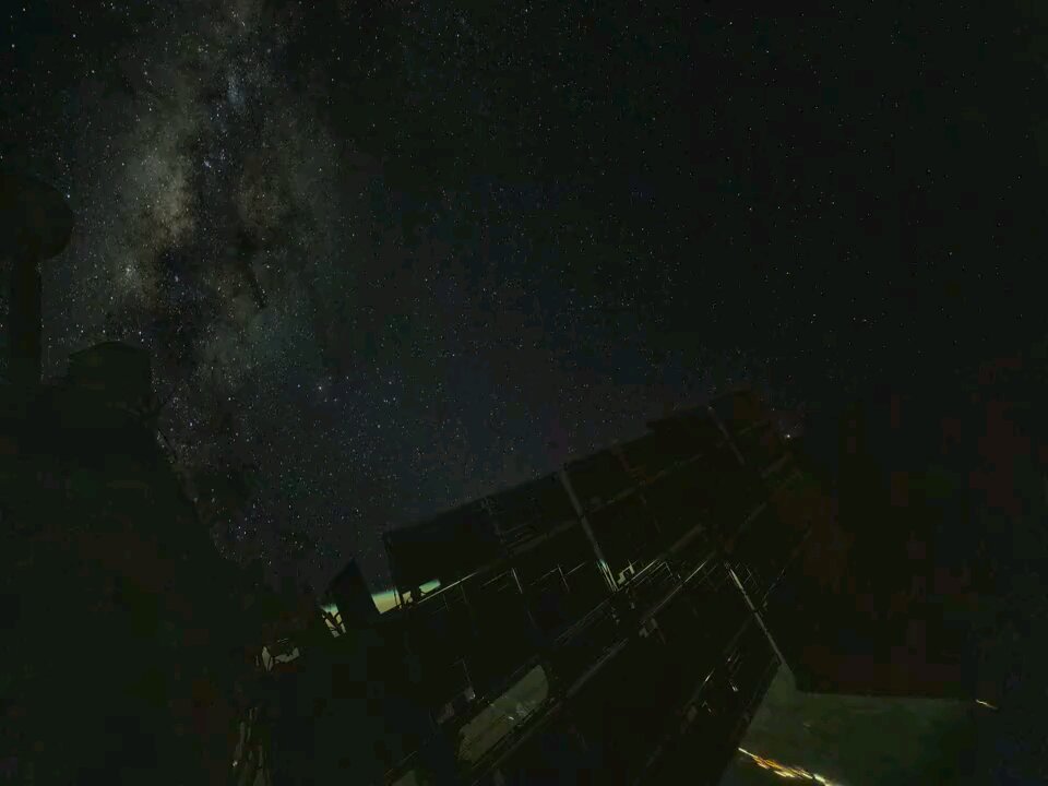 A timelapse of solar arrays reflecting aurora and city lights as they align themselves.