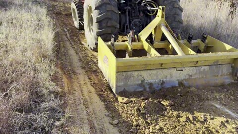 Using the box blade behind the tractor on the very rutted Red Road at the farm (Part 1)