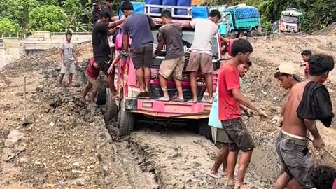 mutual cooperation to pull a truck stuck on a muddy road