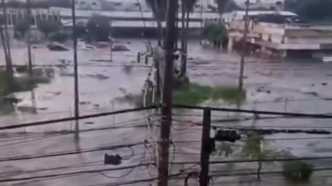 Cars float down brown floods in the Americas amid mass blackouts
