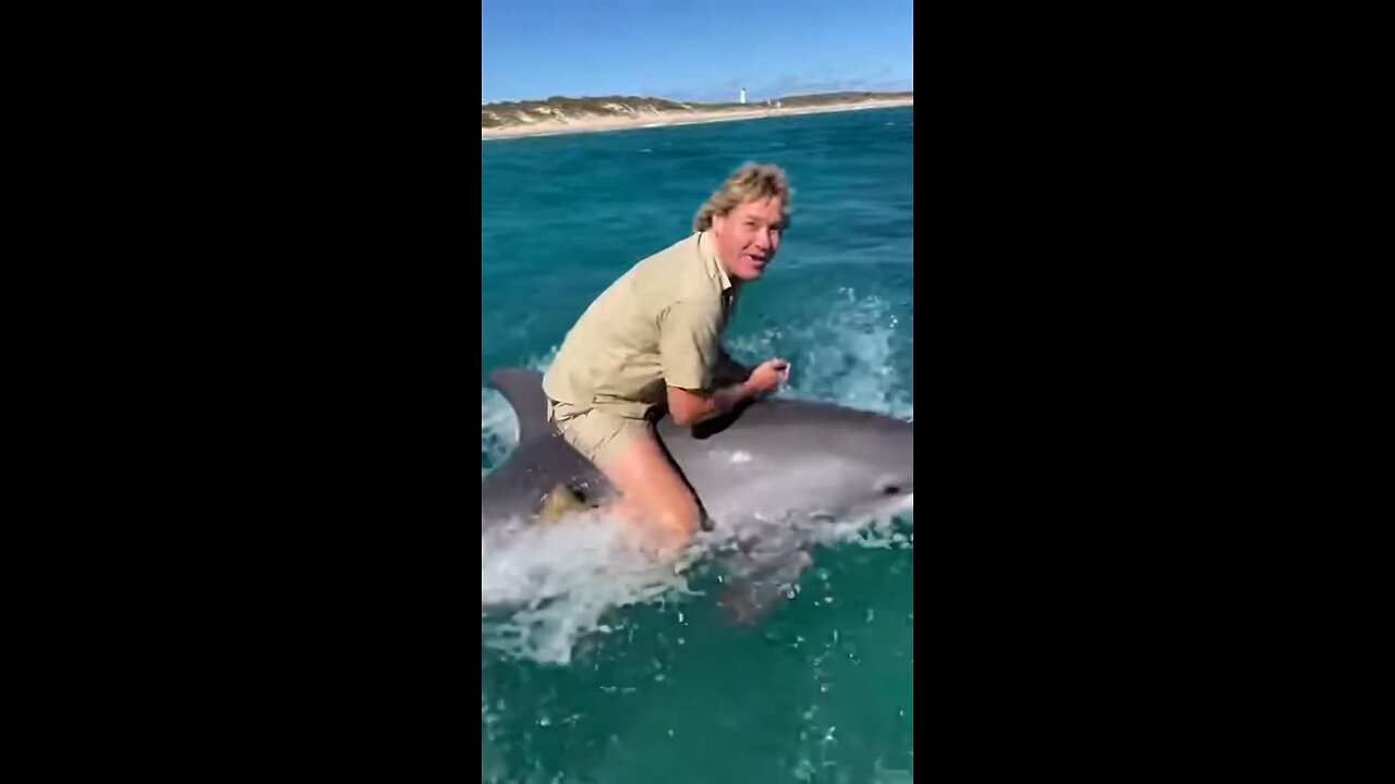 Steve Irwin riding a dolphin