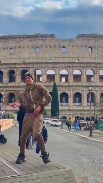 A North African dances with a knife outside the Colosseum in presence of families, children,