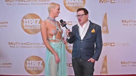 Laura X Desiree of Naked News is interviewed on the red carpet at the 2019 Xbiz Awards