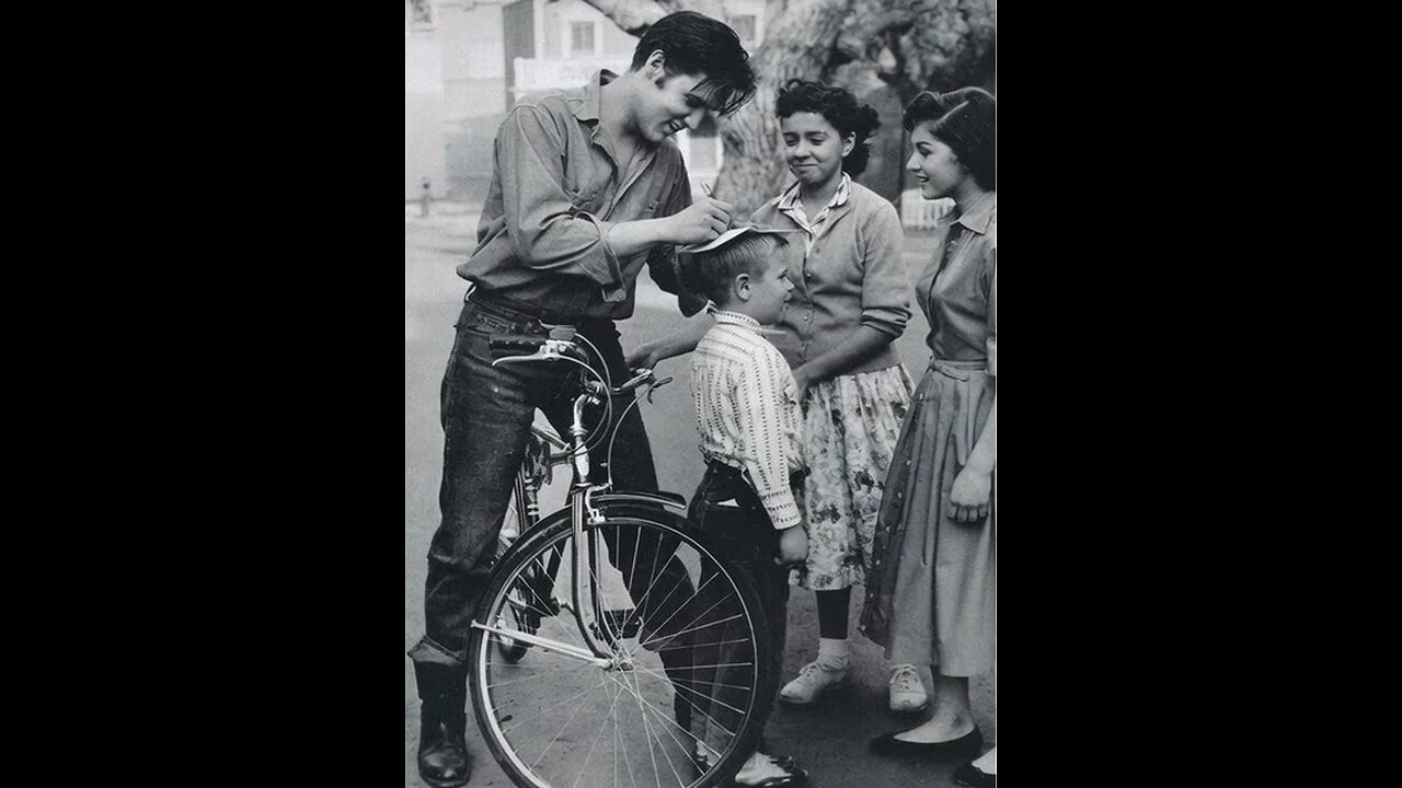 Elvis signing a boy’s head, 1959.