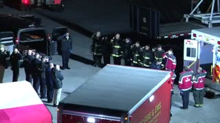 Rescue workers pay their respects as they transport the remains of an