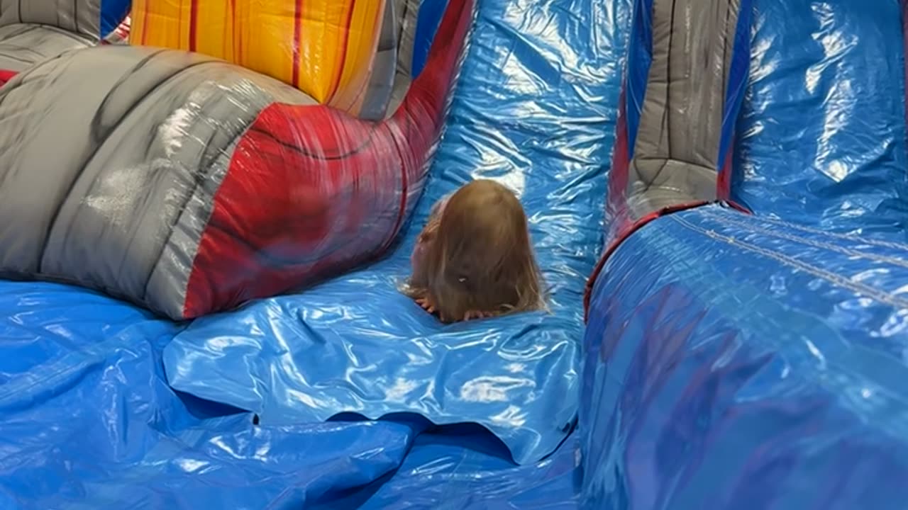 Little Girl Tumbles Down Inflatable Slide