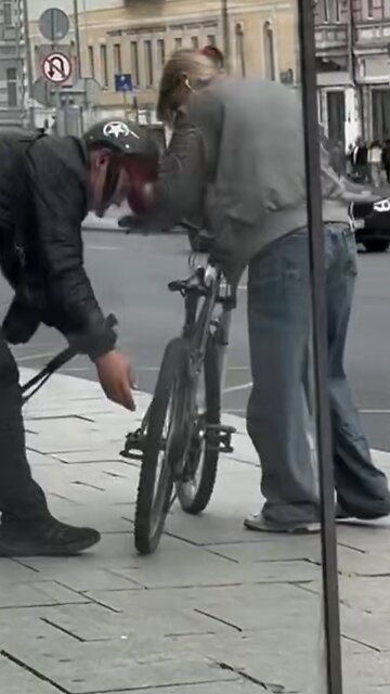 Repartidor ayuda a una mujer con una rueda desinflada de su bicicleta