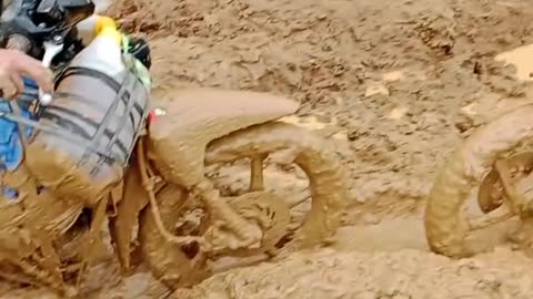 Even though the road is muddy, this motorbike still passes that road