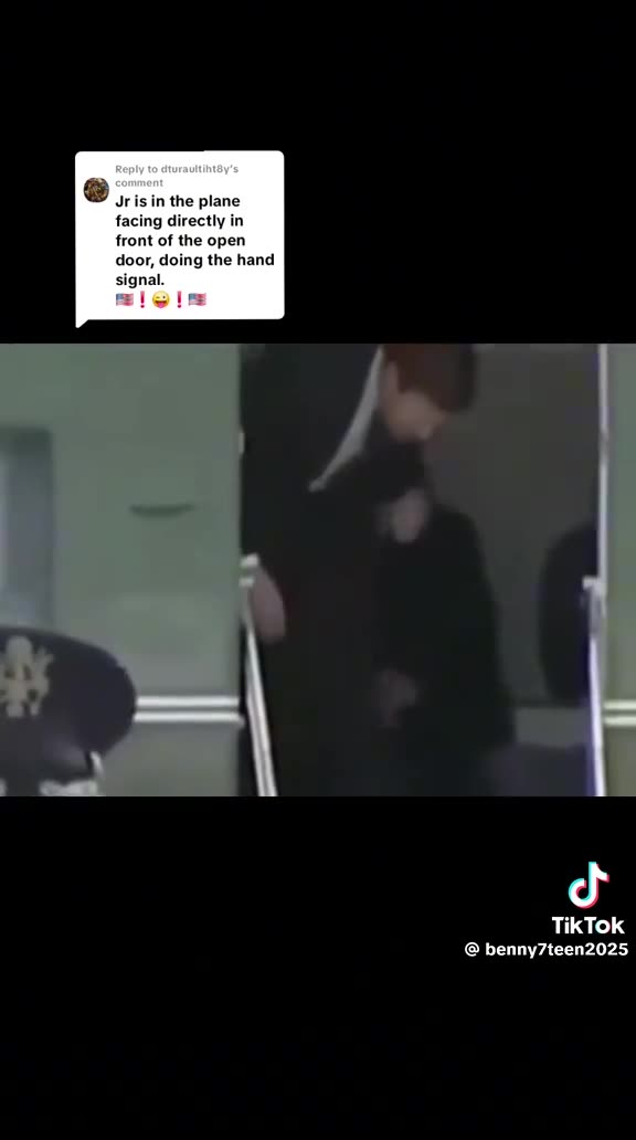 Jr is in the plane facing directly in front of the open door doing the hand signal