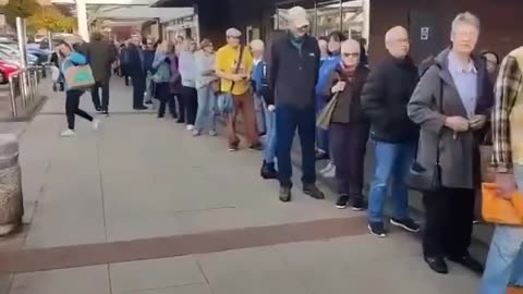 W 2025 roku ludzie w Wielkiej Brytanii stoją w kolejce przed centrum medycznym, czekając na swoją dawkę szczepionki.