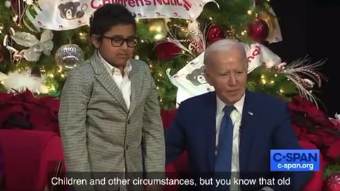 Biden trying to get a kid to sit on his lap..