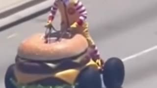 Ronald McDonald driving a hamburger car down the road for shits and giggles