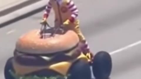 Ronald McDonald driving a hamburger car down the road for shits and giggles
