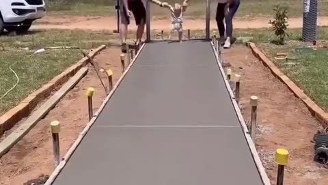 The couple leaving the path to the entrance of their new home with their son's footprints.