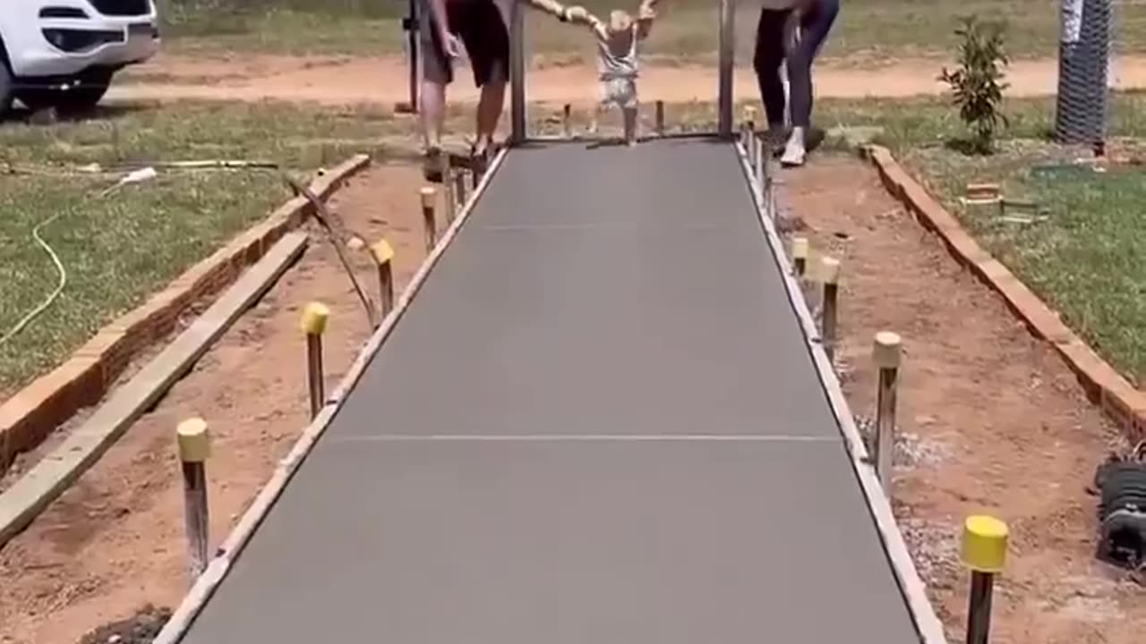 The couple leaving the path to the entrance of their new home with their son's footprints.