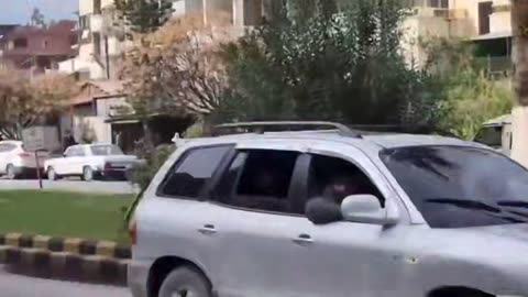 HTS militants firing guns in the air and driving through Latakia amid protests