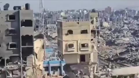 An Israeli occupation soldier poses for a video as he documents the massive destruction