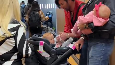 LGBTQI+ influencer shows off designer surrogate baby with husband at airport.