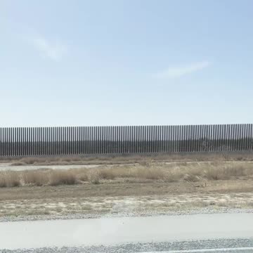 Vance's motorcade passes the border wall